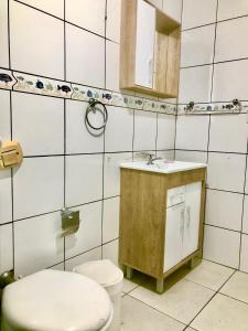 y baño con aseo y lavamanos. en Apto confortável próximo a praia, en Balneário Camboriú