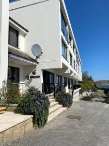 a white building with stairs and plants in front of it at 14 The Old Boatyard in Padstow