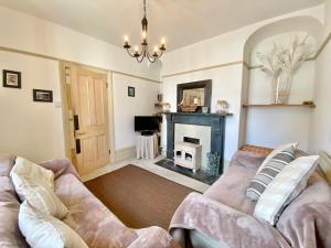 a living room with a couch and a fireplace at Camel Cottage in Padstow
