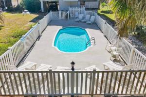 a swimming pool with chairs and a fence at Casablanca - Beach home with heated pool, bikes and more, sleeps 13! in St. George Island