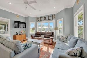 a living room with a couch and a table at Casablanca - Beach home with heated pool, bikes and more, sleeps 13! in St. George Island