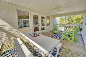 a screened in porch with a table and chairs at Casablanca - Beach home with heated pool, bikes and more, sleeps 13! in St. George Island