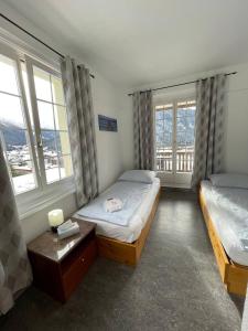 ダボスにあるZentrum Haus Davosのベッドルーム1室(ベッド2台、窓2つ付)