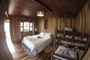 a bedroom with a white bed and a wooden ceiling at Estância Travessia in São Pedro