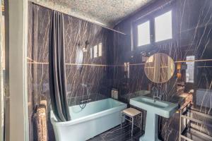 uma casa de banho com uma banheira azul e um lavatório. em Place Vendôme Luxe 60 SQM Bail mobilité em Paris