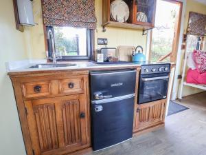 a kitchen with a black refrigerator and a sink at The Suffolk in St Asaph