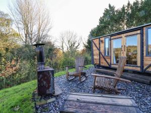 a tiny house with two chairs and a stove at The Suffolk in St Asaph