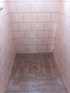 a bathroom with a shower with a tile floor at NAMU Apartments in Katima Mulilo