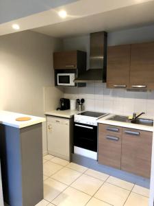 a kitchen with a sink and a stove top oven at Urban Home - 4 pers - Netflix in Eysines