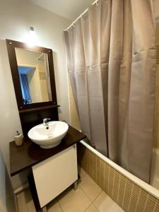 a bathroom with a sink and a shower curtain at Urban Home - 4 pers - Netflix in Eysines