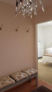 Zimmer mit einer Bank mit einem Kronleuchter und einem Schlafzimmer in der Unterkunft Beauregard-Sous-Gare in Lausanne