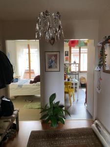un soggiorno con lampadario pendente e una camera da letto di Beauregard-Sous-Gare a Losanna
