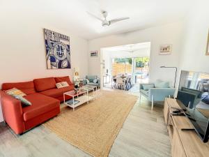 uma sala de estar com um sofá vermelho e uma televisão em Villa Ti Bo Beach, a few steps away from the beach, private pool em Orient Bay