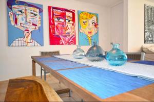 a table with four glass vases on it with paintings at Apartamento frente a la Playa Arecibo Puerto Rico in Arecibo