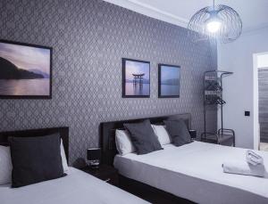 1 dormitorio con 2 camas y lámpara de araña en Hostal Andrea, en Madrid