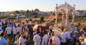 una multitud de personas de pie alrededor de un carruaje tirado por caballos en APARTAMENTO RURAL CASA MONTE, en Cazalla de la Sierra