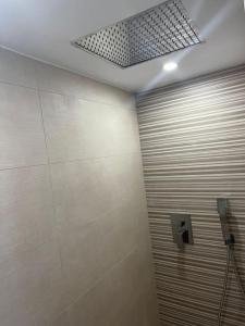 La salle de bains est pourvue d'une cabine de douche et d'un plafond. dans l'établissement LR IFEMA MADRID, à Madrid