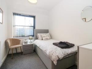una camera da letto con un letto, una sedia e una finestra di Kilmuir Cottage a Tomintoul