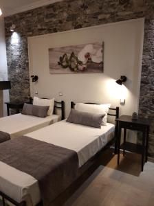 twee bedden in een kamer met een stenen muur bij Sofia Beach Apartments in Kavos