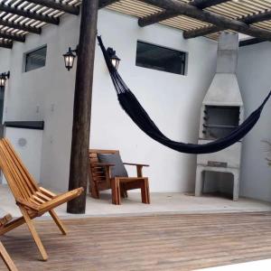 a hammock in a patio with a fireplace at The Guest House hostel in Balneário Gaivotas