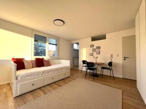 a living room with a white couch and a table at Apartment kleine Auszeit in Dornbirn
