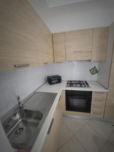 una piccola cucina con lavandino e piano cottura di Appartamenti Le Gemme a Napoli
