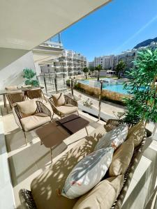 a balcony with pillows and chairs and a pool at Marina Real 82 by homeprive in Denia