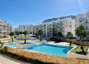 a swimming pool in front of some apartment buildings at Marina Real 82 by homeprive in Denia
