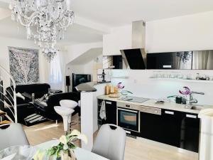 a kitchen and living room with a chandelier at Apartmán Residenz in Poprad