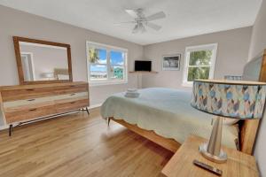 1 dormitorio con cama, tocador y espejo en The Salty Snapper - 2 Story Home, Bay Views, Prime Location, Sleeps 8!, en St. George Island