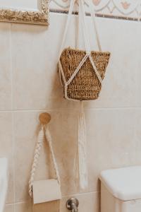a bathroom with a basket hanging on the wall at casademeli ¡Garden and 5 min walk to the beach! in Las Playas