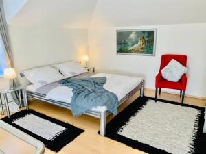 a bedroom with a bed and a red chair at Apartmán Residenz in Poprad
