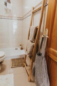 a bathroom with a towel rack next to a bath tub at casademeli ¡Garden and 5 min walk to the beach! in Las Playas