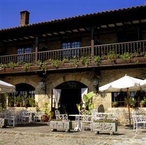 a group of chairs and umbrellas in front of a building at Parador de Santillana del Mar in Santillana del Mar +20 photos