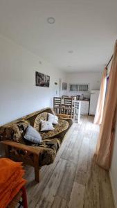 sala de estar con sofá y cocina en Contenedor a metros del mar en Quequén