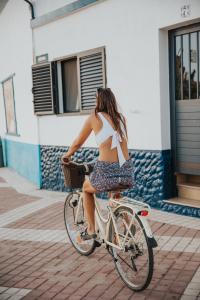 a woman in a bikini riding a bike at casademeli ¡Garden and 5 min walk to the beach! in Las Playas