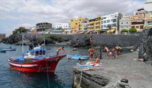 a group of people on a beach with a boat at Casa Paraiso Tenerife in Los Abrigos