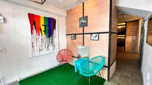 a room with two chairs and a table and a painting at Jet's Gay Youth Hostel in Puerto Vallarta
