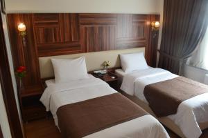 a hotel room with two beds with white sheets at New Fatih Hotel in Istanbul
