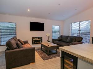 un soggiorno con due divani e un camino di 25 Thirlmere a Windermere