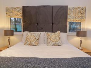 una camera da letto con un grande letto bianco con due lampade di 25 Thirlmere a Windermere