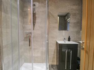 un bagno con doccia, WC e lavandino di 25 Thirlmere a Windermere Altre 19 foto