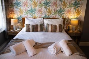 um quarto com uma cama com toalhas em The Wheatsheaf Pub, Kitchen & Rooms em Bingham