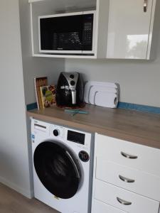 a kitchen with a washing machine and a microwave at Seascape Hideaway Pohara in Pohara