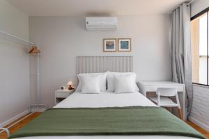 een witte slaapkamer met een groot bed met een groene deken bij Charme na Barra da Tijuca - Bela Vista - AM203 Z10 in Rio de Janeiro
