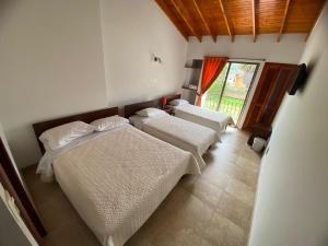1 dormitorio con 2 camas y ventana en San Gabriel Hospedería en Tibasosa