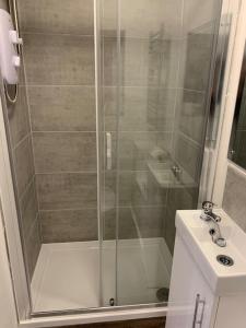 una ducha con una puerta de cristal junto a un lavabo en 4. Immaculate 2 Bedroom Flat, en Birmingham