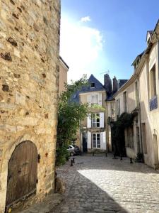 a stone building with a wooden door on a street at Appartement dans le Vieux Mans in Le Mans