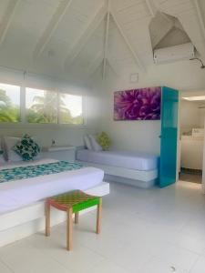 圣安德烈斯Casa de las Flores tropical的有两张床和一张桌子的房间
