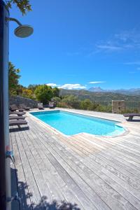 a swimming pool on a wooden deck with mountains in the background at Campu Latinu in Lama